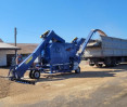 La máquina limpiadora de granos autopropulsada OBC-70M4L limpia y carga trigo en un camión en la era de trilla. Foto La máquina limpiadora de granos autopropulsada OBC-70M4L limpia y carga trigo en un camión. Foto